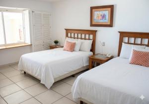 a bedroom with two beds and a window at Beachfront view Condo beside la Isla Mall in Puerto Vallarta