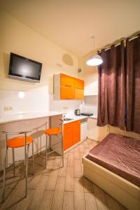 een kleine kamer met een bed en een keuken bij Mini Apartment on Rappoporta 7a-3 in Lviv