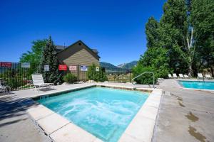 a swimming pool in a yard next to a house at Bigfoots Alpine Retreat MH710By Powder Mtn Hot Tub in Eden