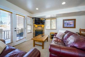 a living room with a leather couch and a table at Bigfoots Alpine Retreat MH710By Powder Mtn Hot Tub in Eden