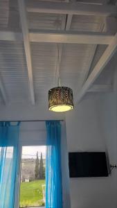 a light hanging from a ceiling in a room with a window at White and Blue in Mesimvría