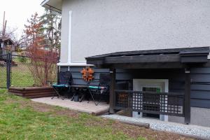 a house with a patio with two chairs and a cross at The Kalamoir Suite in West Kelowna