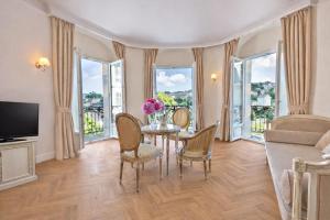 a dining room with a table and chairs and windows at Grand Hôtel Moderne in Lourdes