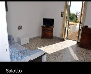 a bedroom with a bed and a tv and a table at Grande Procida in Procida