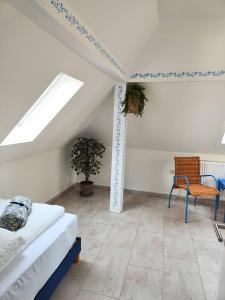 a attic room with a bed and a chair at Weserblick Hafen-Villa-Bremen in Bremen