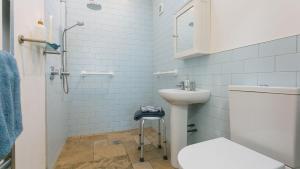 a white bathroom with a sink and a toilet at Pen Bonc in Moelfre +71 photos
