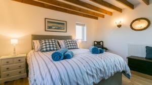 a bedroom with a bed with blue towels on it at Pen Bonc in Moelfre
