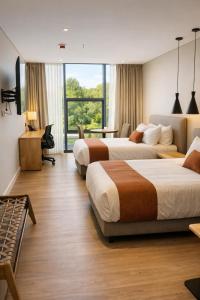 a hotel room with two beds and a desk at Hotel B3 Sibelius in Chía
