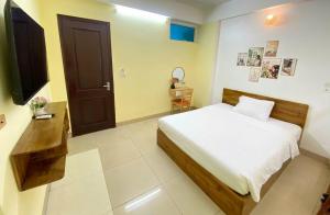a bedroom with a bed and a television in it at Hi Hotel in Kỳ Vĩ +73 photos