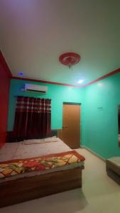 a room with a bed and a green wall at Hotel kashish in Waigaon