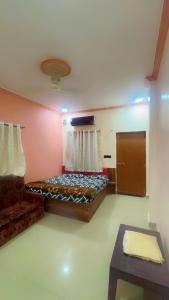 a bedroom with a bed and a couch and a table at Hotel kashish in Waigaon