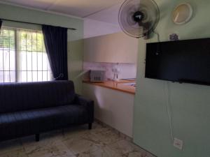 a living room with a couch and a flat screen tv at Turtle Sands Holiday Home in Richards Bay