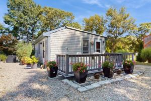 a tiny house with potted plants on a gravel driveway at 2 Mi to Dowses Beach! Couples Haven in Osterville in Osterville
