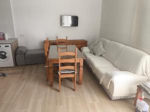 a living room with a couch and a table and a table and chair at Casa Campo Gerena in Sanlúcar de Barrameda +1 photo