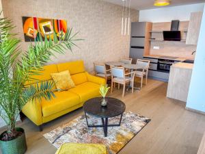 a living room with a yellow couch and a table at Eurovea Tower Apartment 27th floor, Luxury bed VISPRING Baronet Superb in Ovsište