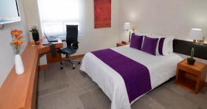 a hotel room with a bed and a desk at Hotel Lois Express Monterrey Aeropuerto La Fe in Monterrey +19 photos