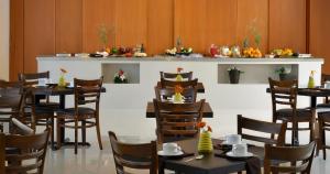 a restaurant with tables and chairs in a room at Hotel Lois Express Monterrey Aeropuerto La Fe in Monterrey