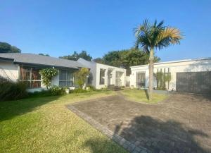 a palm tree in the yard of a house at Turtle Sands Holiday Home in Richards Bay