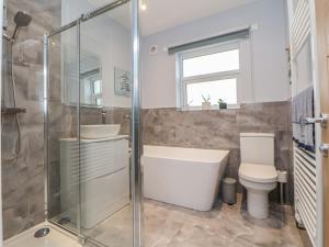 a bathroom with a tub and a toilet and a sink at Mikes Place On The Cove in Rhyl +29 photos