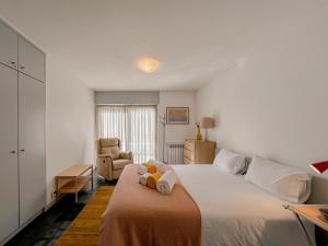 a bedroom with a bed with two stuffed animals on it at Casa das Rampas - Nature Retreat with Pool in Moledo +55 photos