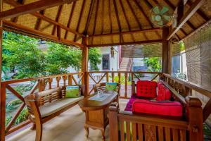 a screened in porch with benches and a table at Whiterose Guesthouse in Senggigi