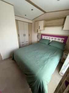 a bedroom with a large green bed in it at 6 berth caravan in Ingoldmells opposite beach in Ingoldmells