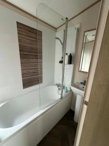 a bathroom with a shower and a tub and a sink at 6 berth caravan in Ingoldmells opposite beach in Ingoldmells +11 photos