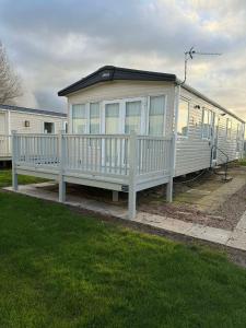 a large white mobile home with a porch at 6 berth caravan in Ingoldmells opposite beach in Ingoldmells