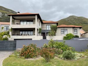 a house with a fence in front of it at Chasing Jacuzzi Sunsets sea and mountain views in Hermanus