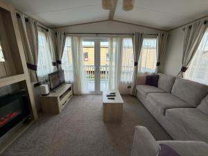 a living room with a couch and a tv at 6 berth caravan in Ingoldmells opposite beach in Ingoldmells