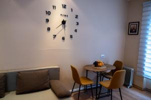 a living room with a couch and a clock on the wall at Apartmani Prestige in Gornji Vakuf