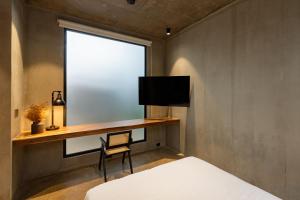 a bedroom with a desk and a window and a bed at The Terrace Retreat in Jacó