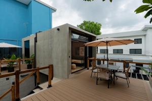 a wooden deck with a table and an umbrella at The Terrace Retreat in Jacó