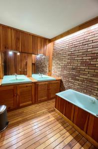 ein Badezimmer mit zwei Waschbecken und einer Badewanne in der Unterkunft Appart Hôtel Ambert in Marsac-en-Livradois