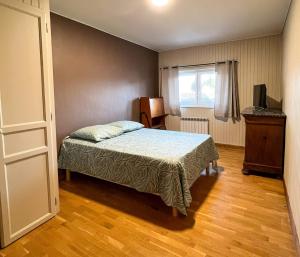 ein kleines Schlafzimmer mit einem Bett und einem Fenster in der Unterkunft Appart Hôtel Ambert in Marsac-en-Livradois + 9 Fotos