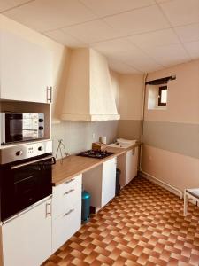 a kitchen with white cabinets and a black stove top oven at Levroux - maison 4-6 pers - cour privee in Levroux