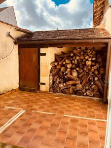 a garage with a wall full of logs at Levroux - maison 4-6 pers - cour privee in Levroux