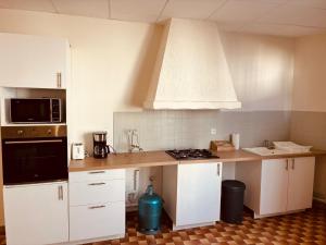 a kitchen with white cabinets and a counter top at Levroux - maison 4-6 pers - cour privee in Levroux +16 photos