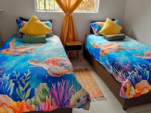 a bedroom with two beds with mermaid themed sheets at Turtle Sands Holiday Home in Richards Bay +12 photos