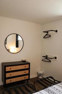 a bedroom with a dresser and a mirror on the wall at The Kalamoir Suite in West Kelowna