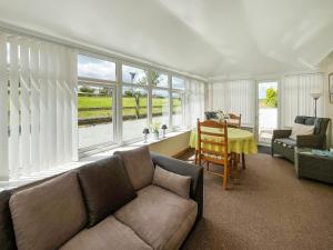 a living room with a couch and a table and windows at Uk47549 - Carty Cottage in Newton Stewart