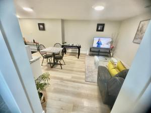 a living room with a couch and a flat screen tv at Airport Getaway- 4 mins from Airport in Dieppe