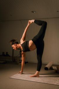 a woman doing a yoga pose on a yoga mat at Alex Alpine Resort - Spa & Sports in Zermatt
