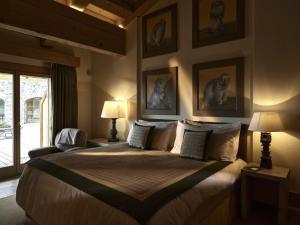 a bedroom with a large bed with pictures on the wall at LeCrans in Crans-Montana