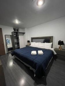 a bedroom with a large bed with two towels on it at AR SUITES DEPARTAMENTO CENTRO 3 in Zamora de Hidalgo