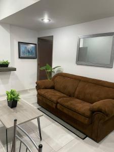 a brown couch in a living room with a table at AR SUITES DEPARTAMENTO CENTRO 3 in Zamora de Hidalgo