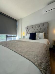 a bedroom with a large bed with a large headboard at AR Suites 3 La Calzada in Zamora de Hidalgo