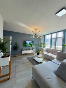 a living room with a couch and a tv at AR Suites 3 La Calzada in Zamora de Hidalgo