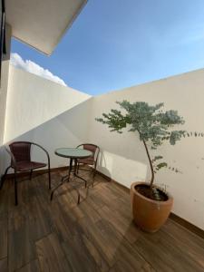 a table and chairs and a small tree in a room at AR Suites 3 La Calzada in Zamora de Hidalgo