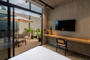 a bedroom with a balcony with a table and a tv at The Penthouse Perch in Jacó